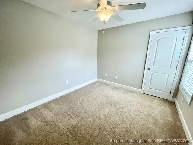 an empty room with a chandelier fan