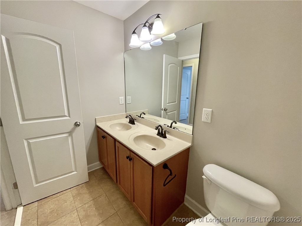 148 Pine Hawk Drive Spring Lake, NC 28390 - Photo 16 of 22 a bathroom with a toilet sink and mirror