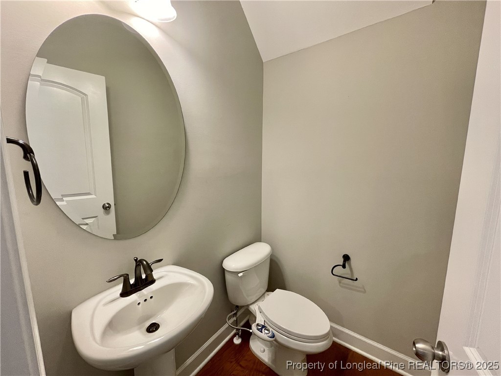 148 Pine Hawk Drive Spring Lake, NC 28390 - Photo 2 of 22 a bathroom with a toilet sink and mirror