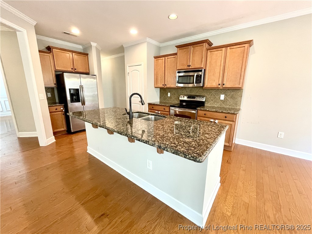 148 Pine Hawk Drive Spring Lake, NC 28390 - Photo 5 of 22 a view of a kitchen with kitchen island a sink wooden floor and counter top space
