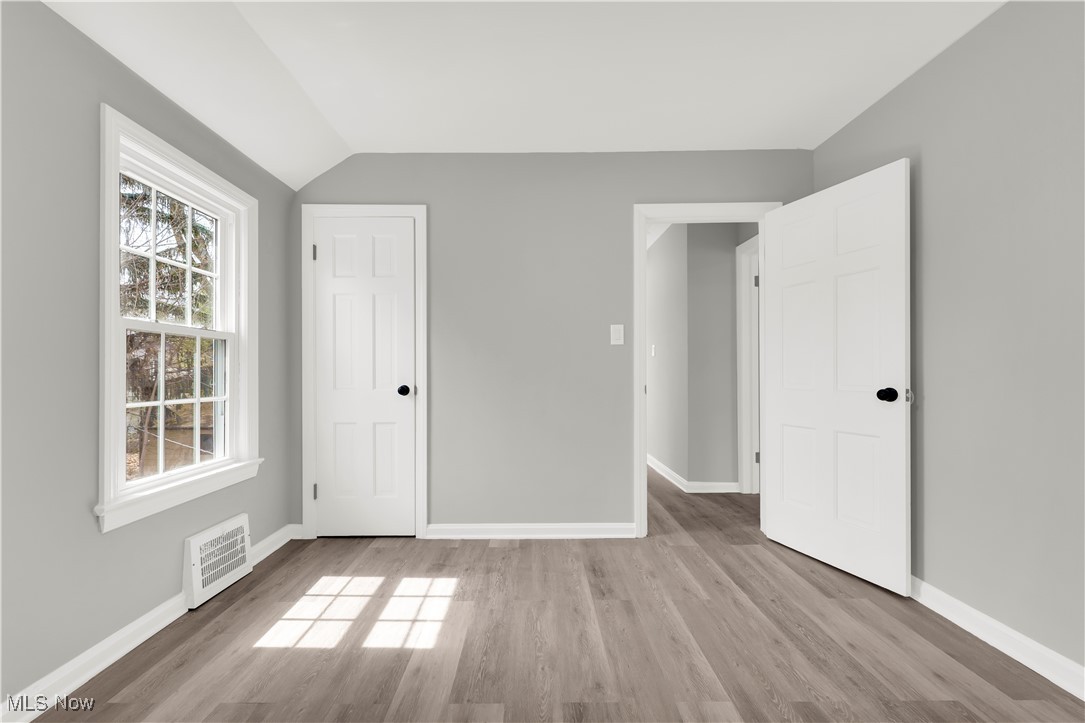3964 Navahoe Road Cleveland Heights, OH 44121 - Photo 20 of 30 Unfurnished bedroom featuring baseboards, visible vents, wood finished floors, and vaulted ceiling