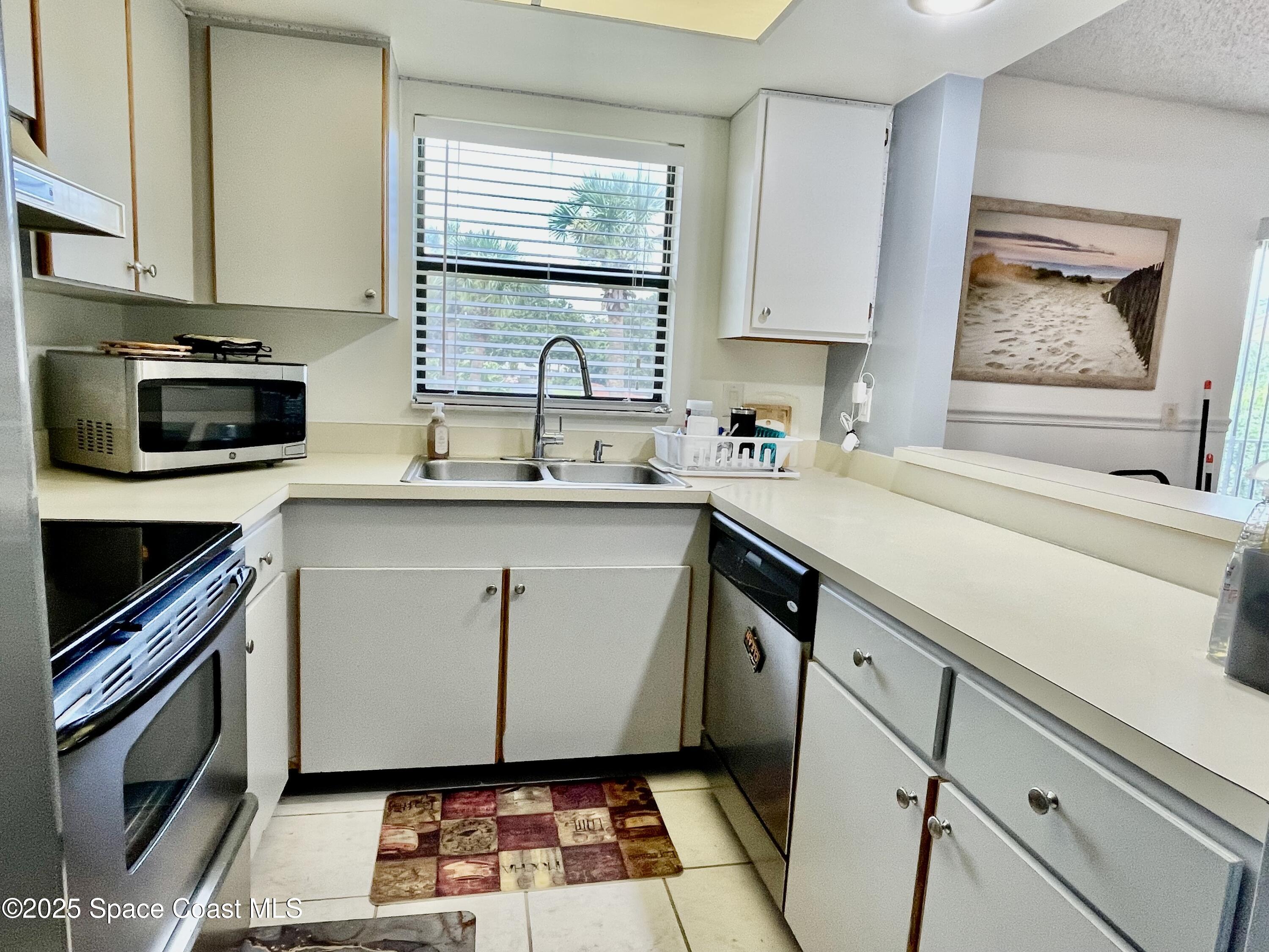 594 North Wickham Road, Unit 2 Melbourne, FL 32935 - Photo 11 of 42 a kitchen with a sink stove and cabinets