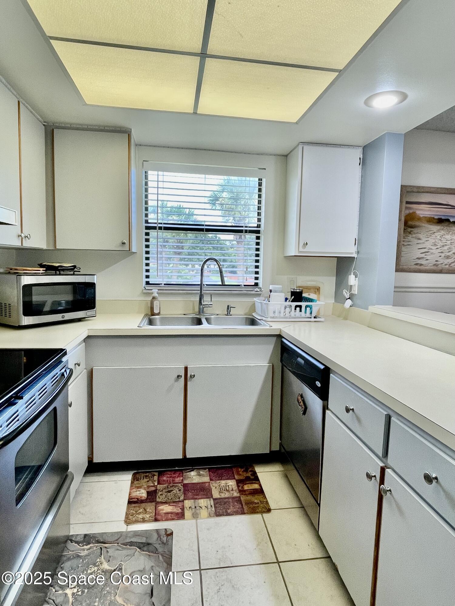 594 North Wickham Road, Unit 2 Melbourne, FL 32935 - Photo 12 of 42 a kitchen with a sink a stove and cabinets