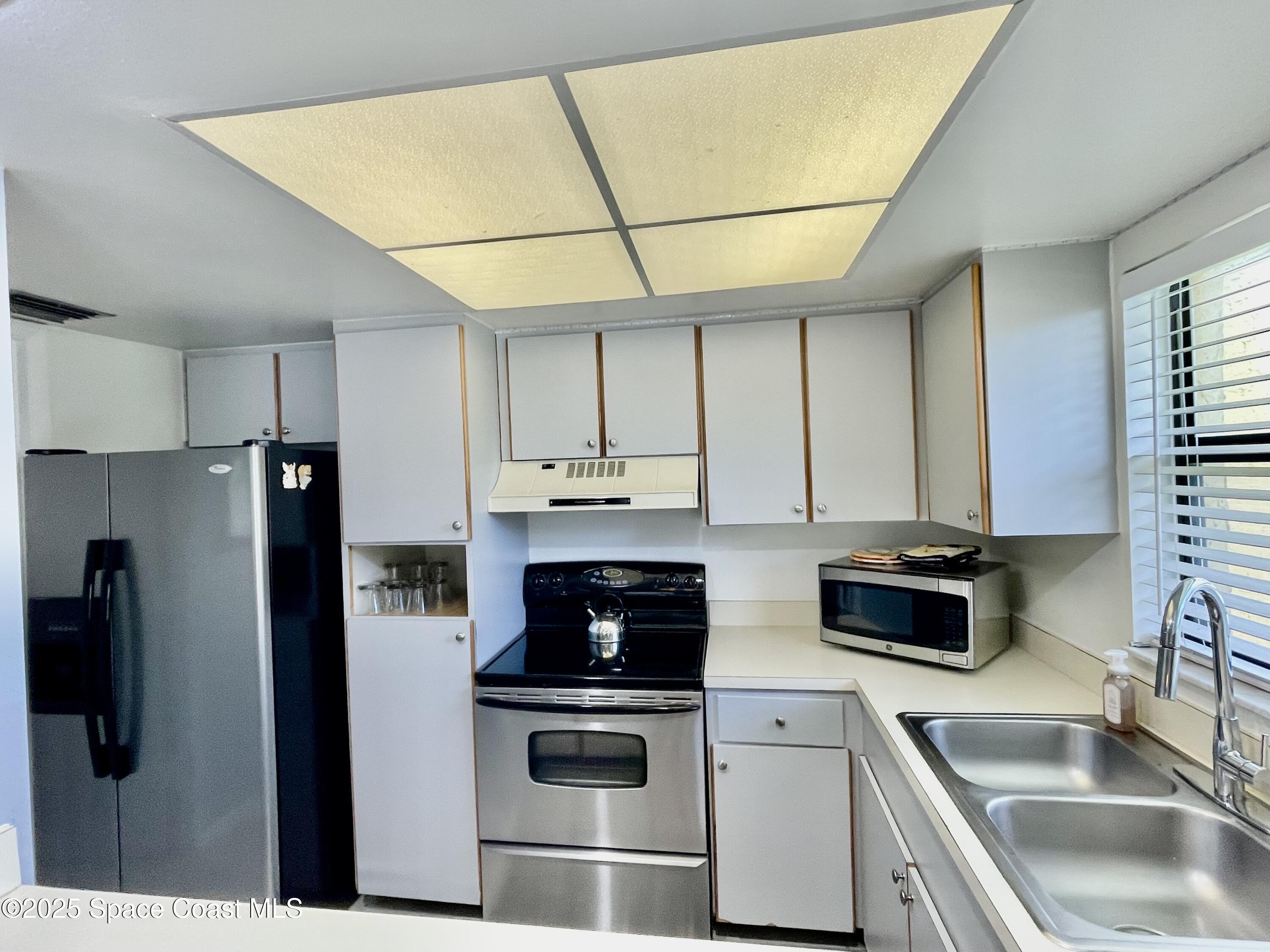 594 North Wickham Road, Unit 2 Melbourne, FL 32935 - Photo 13 of 42 a kitchen with stainless steel appliances a stove a sink a refrigerator a counter space and cabinets