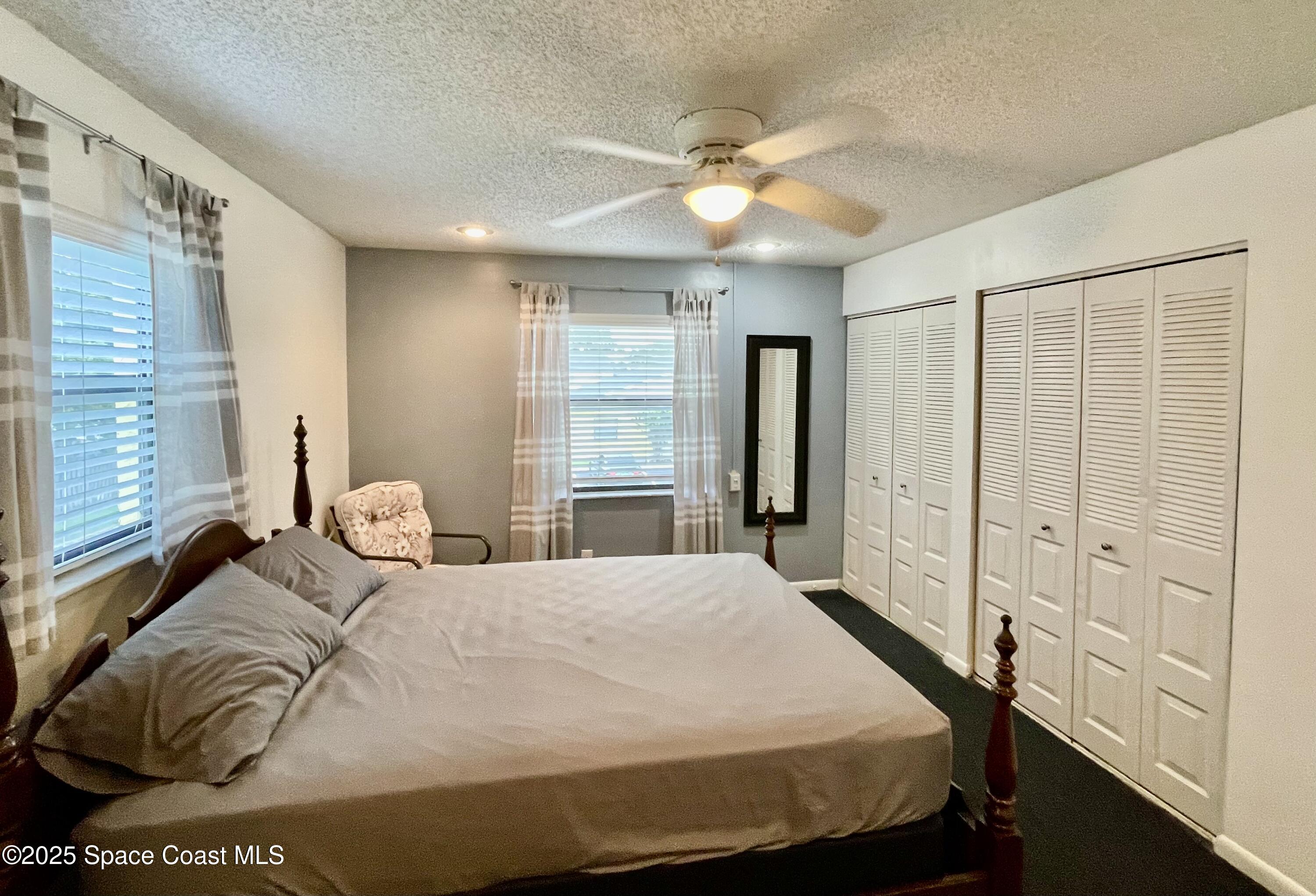 594 North Wickham Road, Unit 2 Melbourne, FL 32935 - Photo 17 of 42 a bedroom with a bed and a chandelier