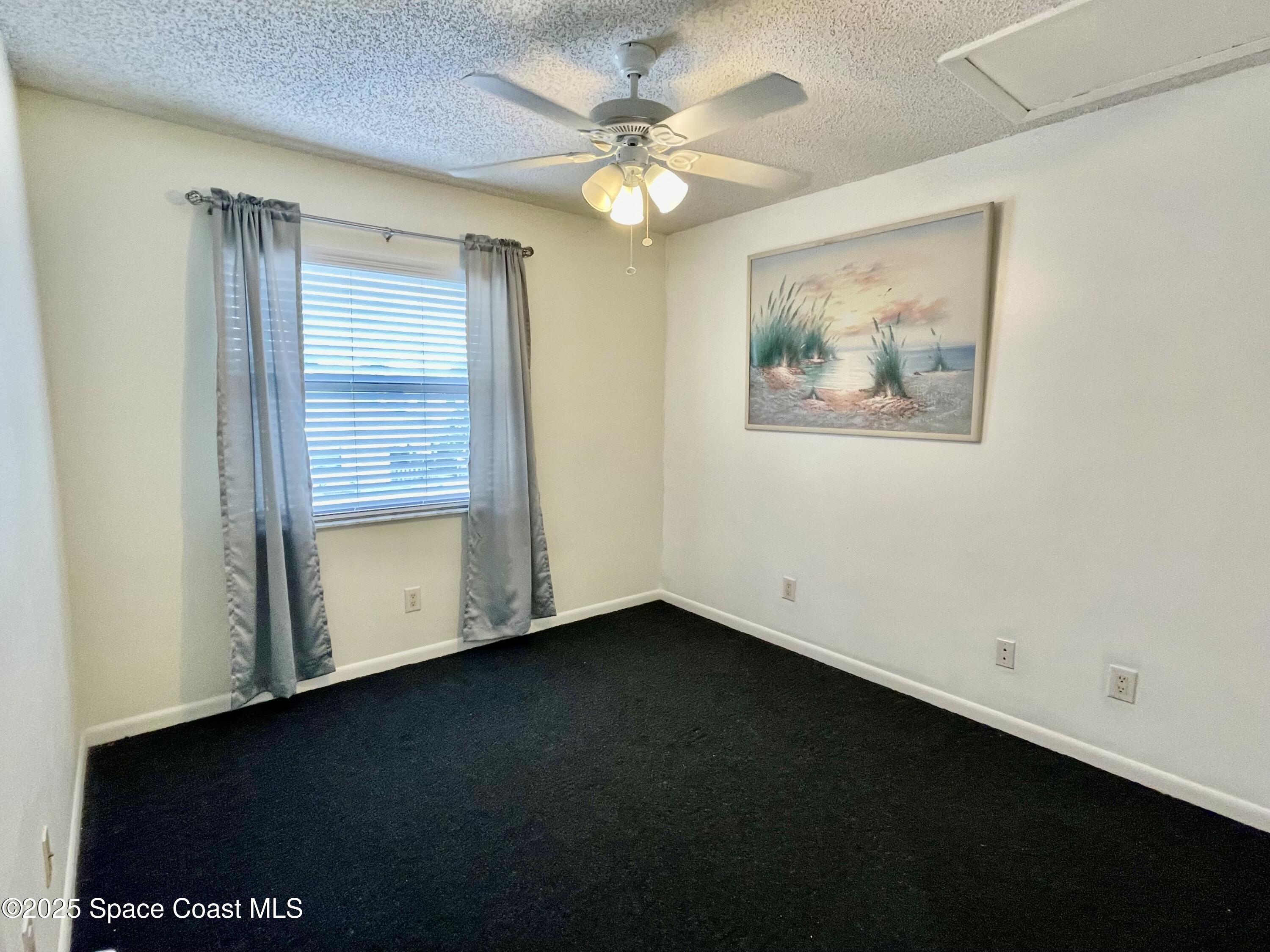 594 North Wickham Road, Unit 2 Melbourne, FL 32935 - Photo 21 of 42 an empty room with a ceiling fan and window