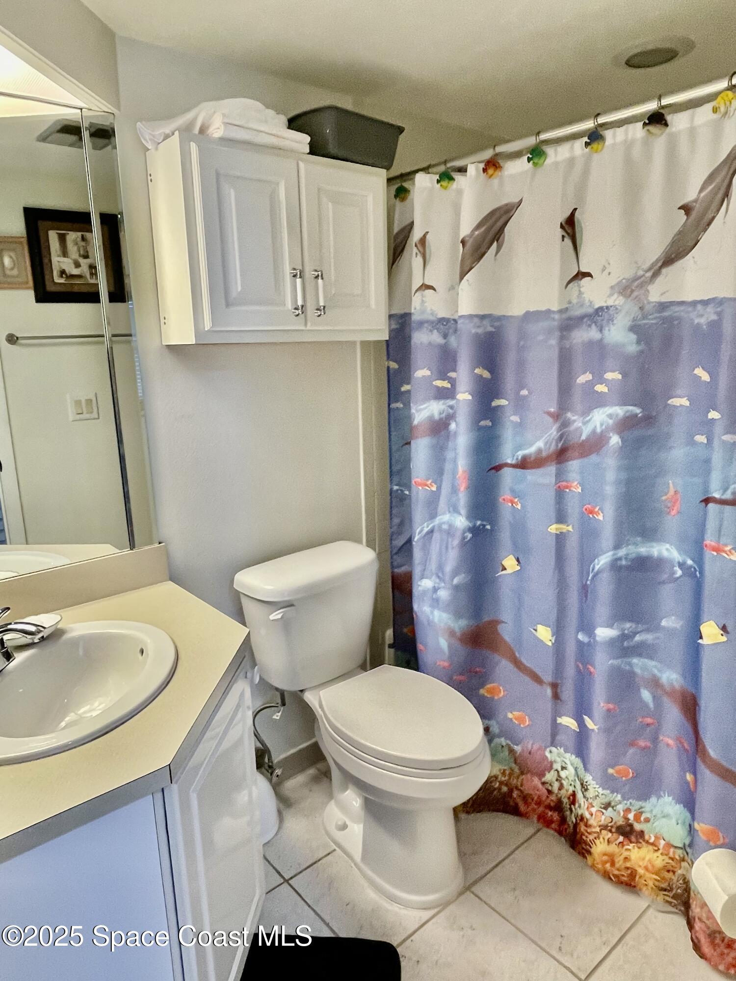 594 North Wickham Road, Unit 2 Melbourne, FL 32935 - Photo 24 of 42 a white toilet sitting next to a bathroom sink and a shower