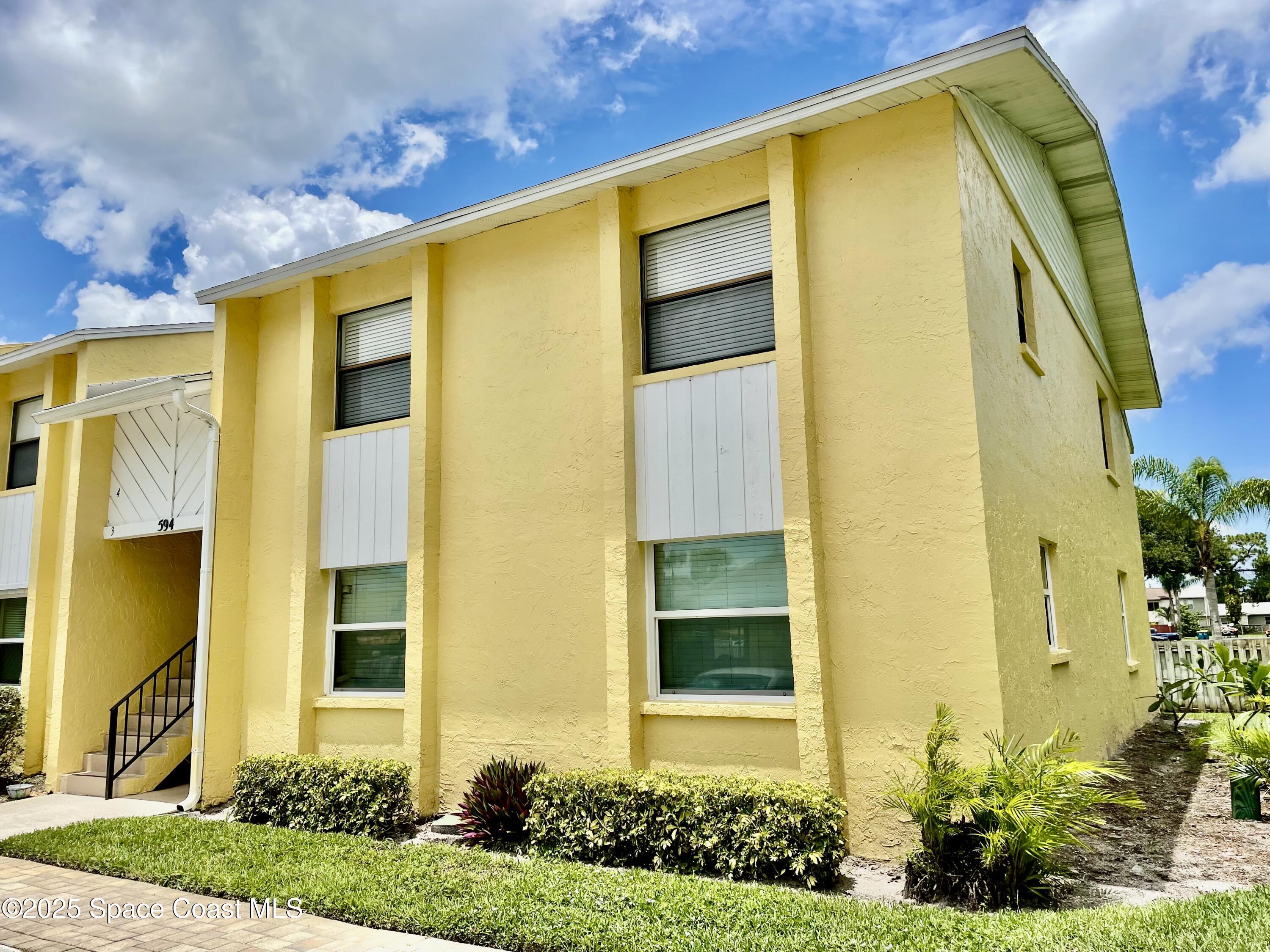 594 North Wickham Road, Unit 2 Melbourne, FL 32935 - Photo 32 of 42 a front view of a house with a yard