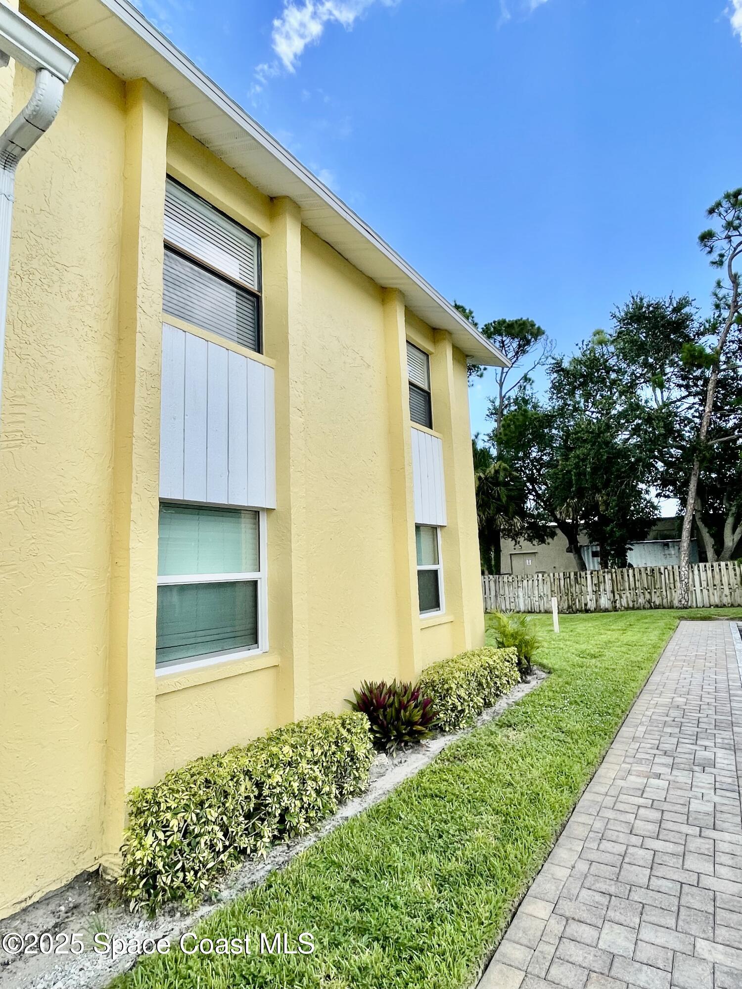 594 North Wickham Road, Unit 2 Melbourne, FL 32935 - Photo 33 of 42 a front view of a house with a yard