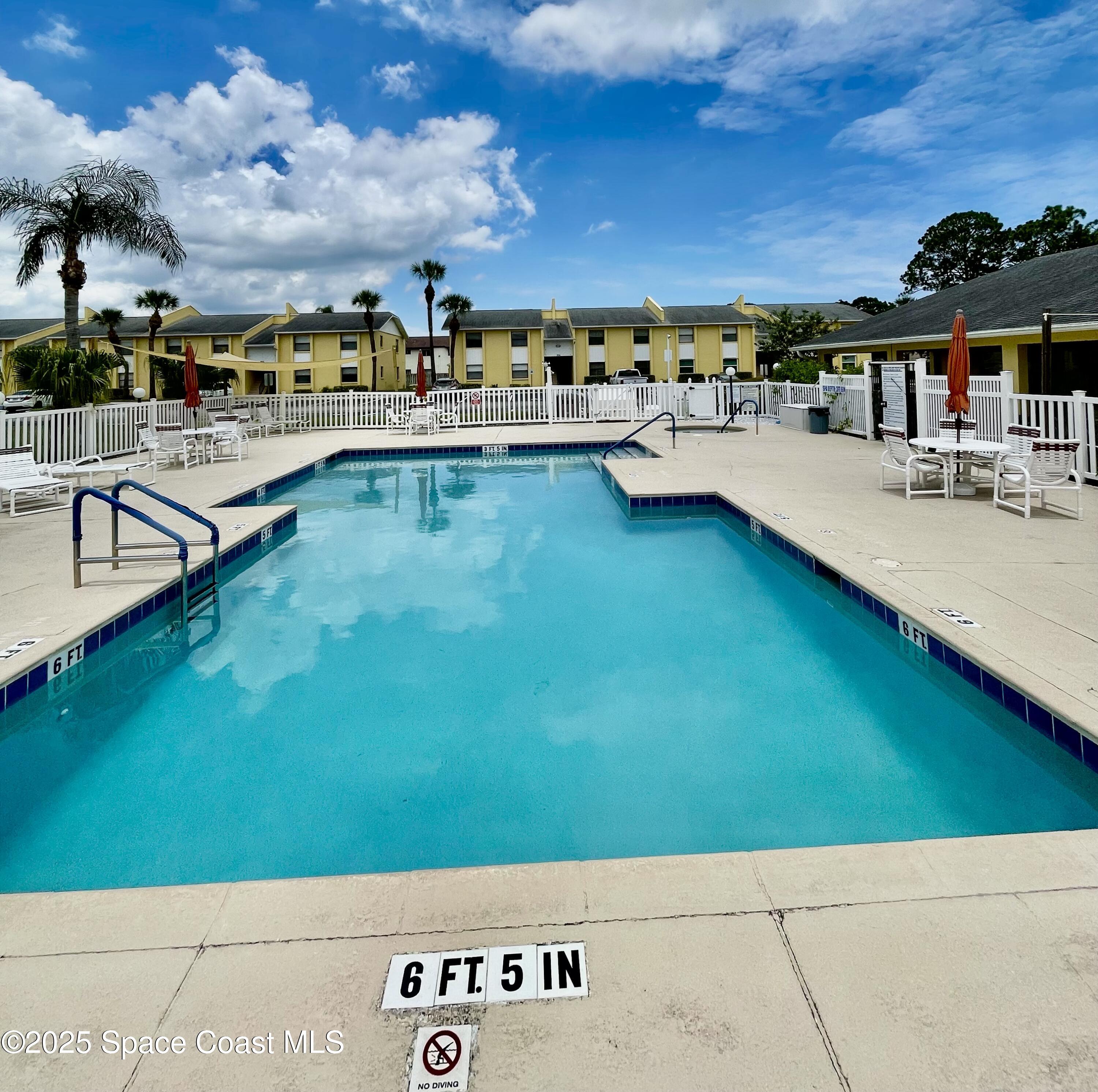 594 North Wickham Road, Unit 2 Melbourne, FL 32935 - Photo 36 of 42 a view of a swimming pool with a chair and tables