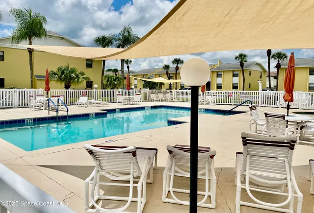 a view of a patio with couches chairs table and chairs with wooden floor and fence