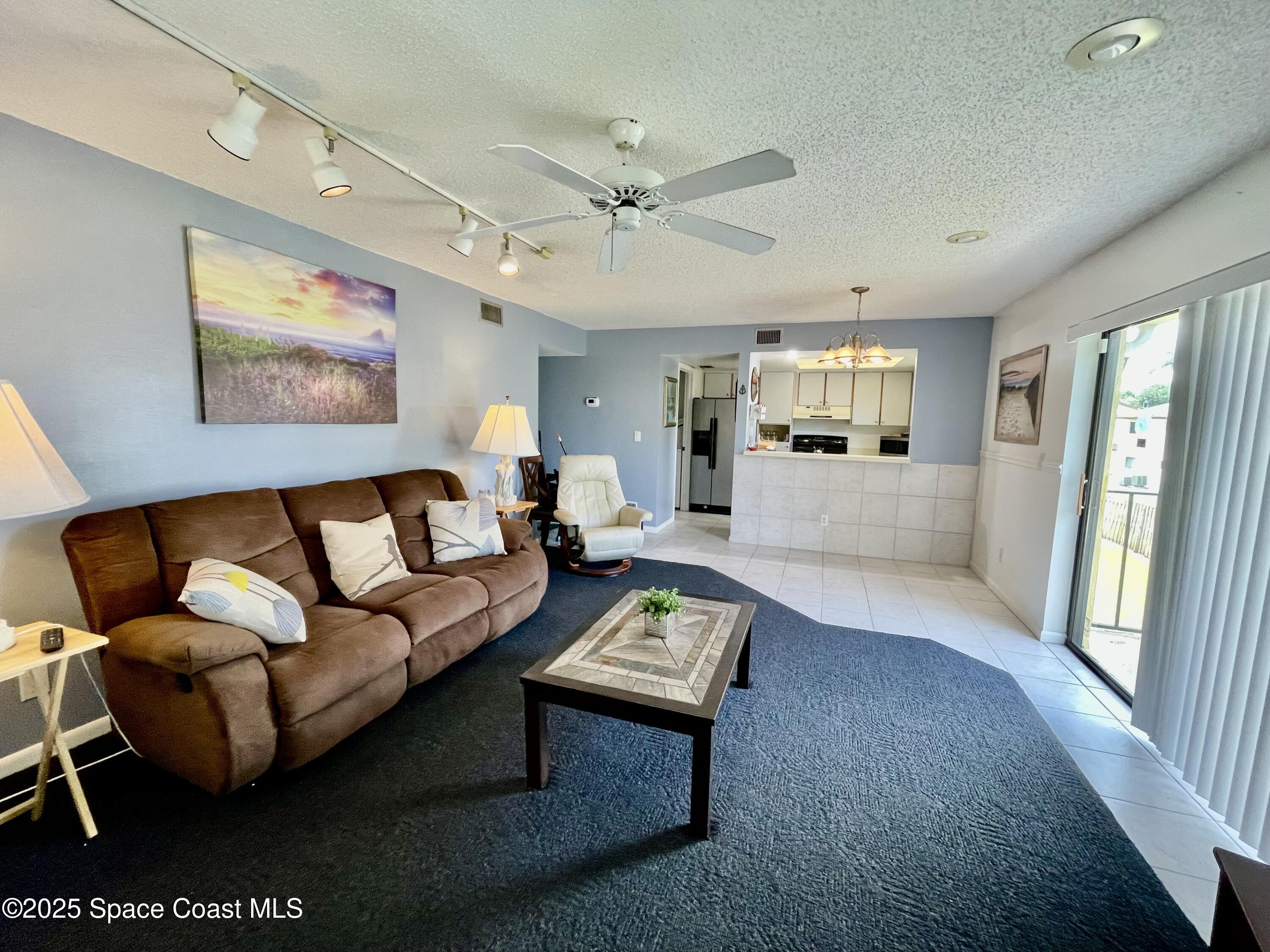 594 North Wickham Road, Unit 2 Melbourne, FL 32935 - Photo 8 of 42 a living room with furniture and a large window
