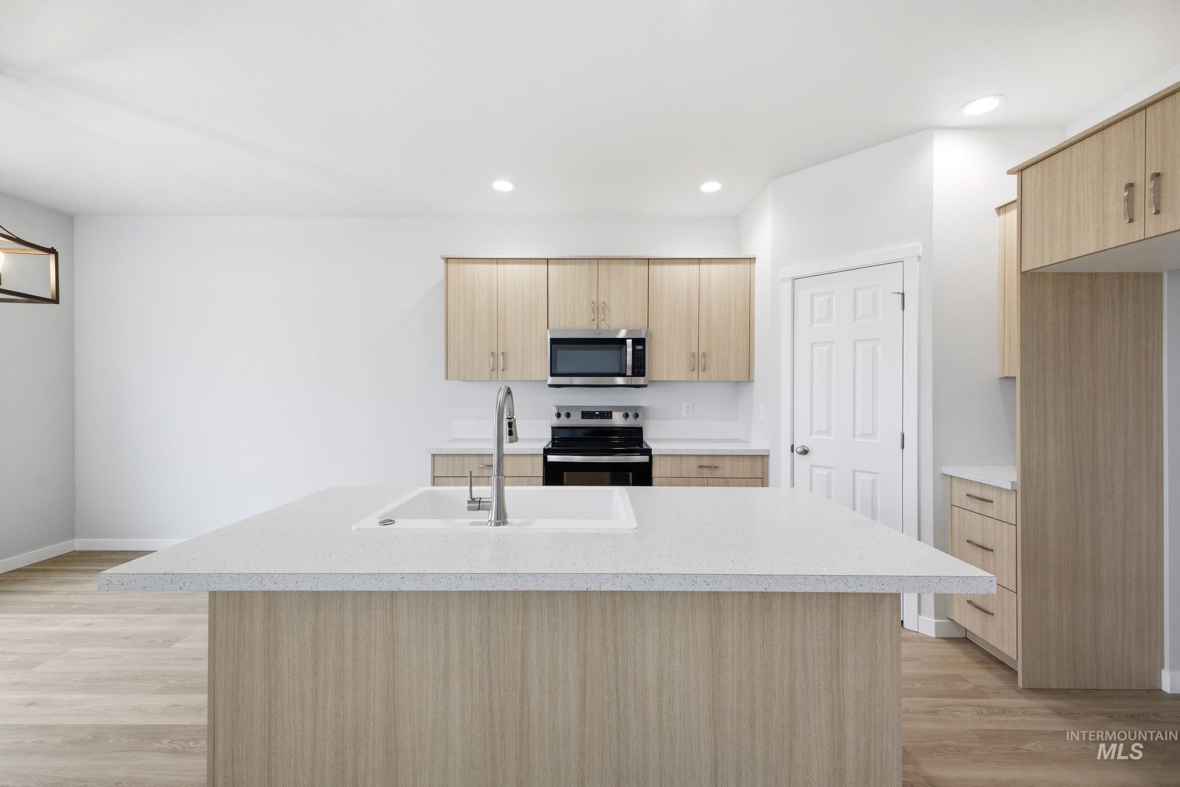 14104 Shiny Spruce Street Caldwell, ID 83607 - Photo 3 of 20 Kitchen featuring a spacious island with an integrated sink and gooseneck faucet