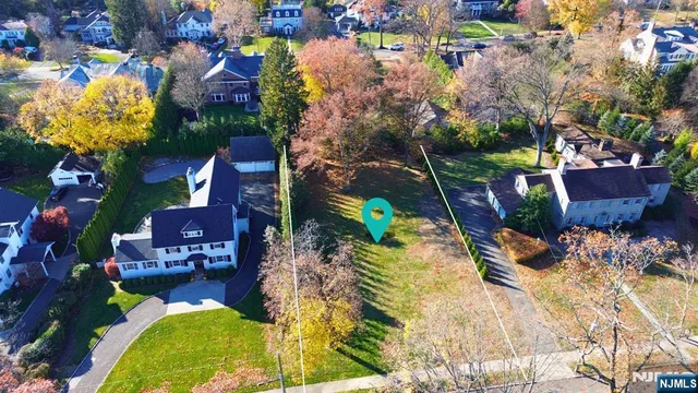 an aerial view of a house with a yard and large trees