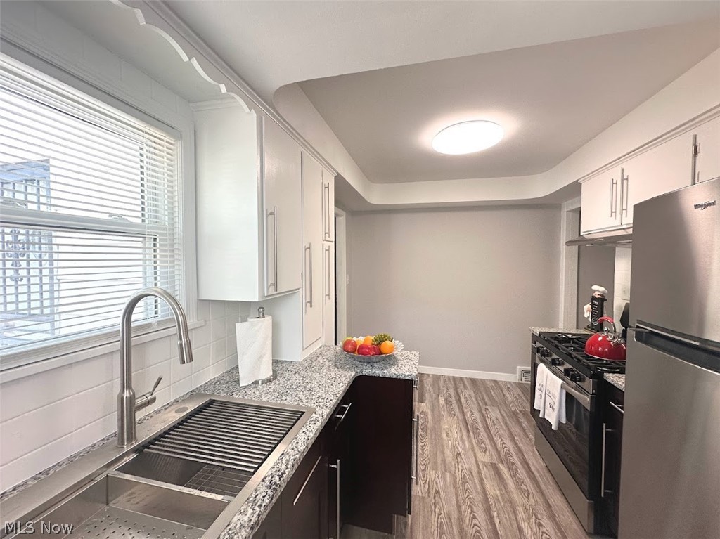 4227 Eastway Road South Euclid, OH 44121 - Photo 6 of 18 Kitchen with plenty of natural light, white cabinetry, stainless steel appliances, and light hardwood / wood-style floors