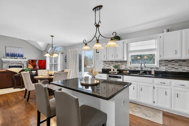 a kitchen with granite countertop a sink a counter top space appliances and cabinets