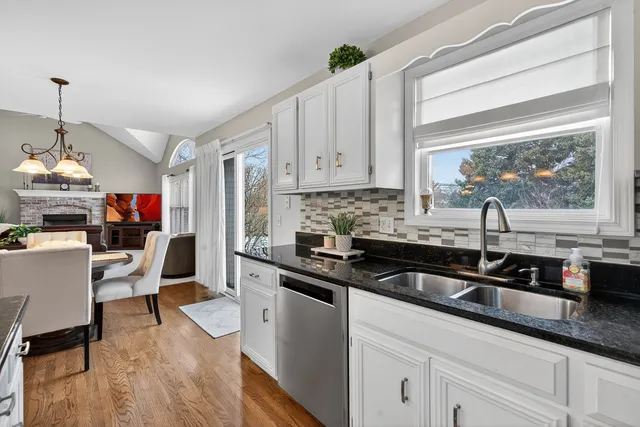 a kitchen with granite countertop a sink stove and cabinets