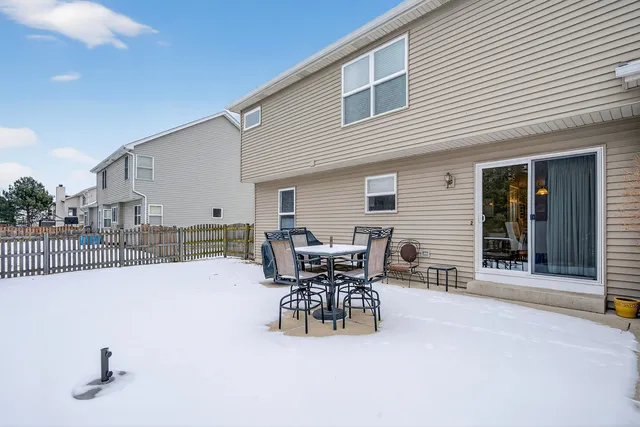 a patio with table and chairs and potted plants