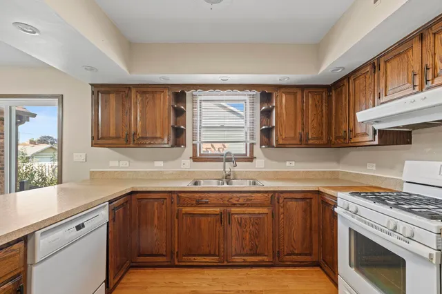 a kitchen with a sink cabinets appliances and a window