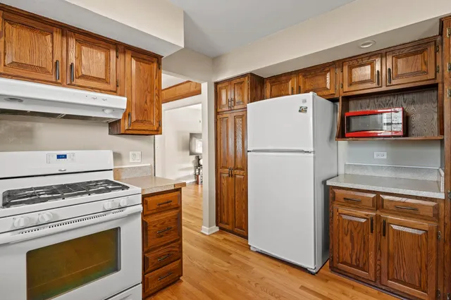 a white refrigerator freezer and a stove sitting inside of a kitchen