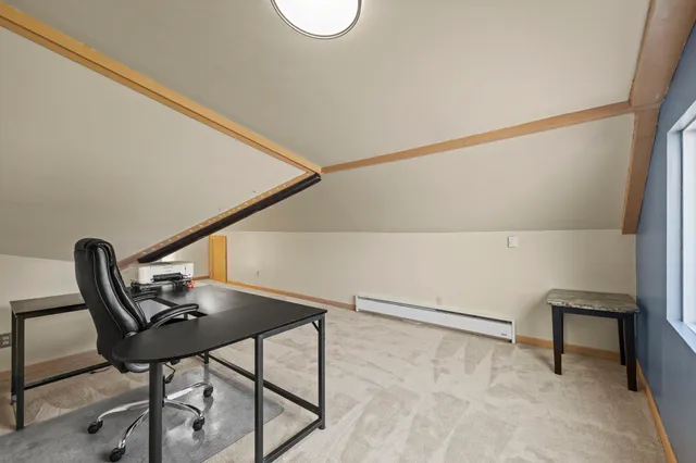 a view of a workspace with furniture and a window