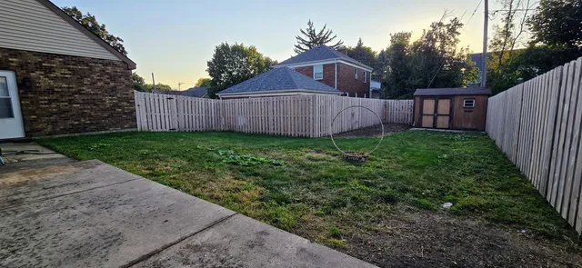 a view of a house with backyard and wooden fence