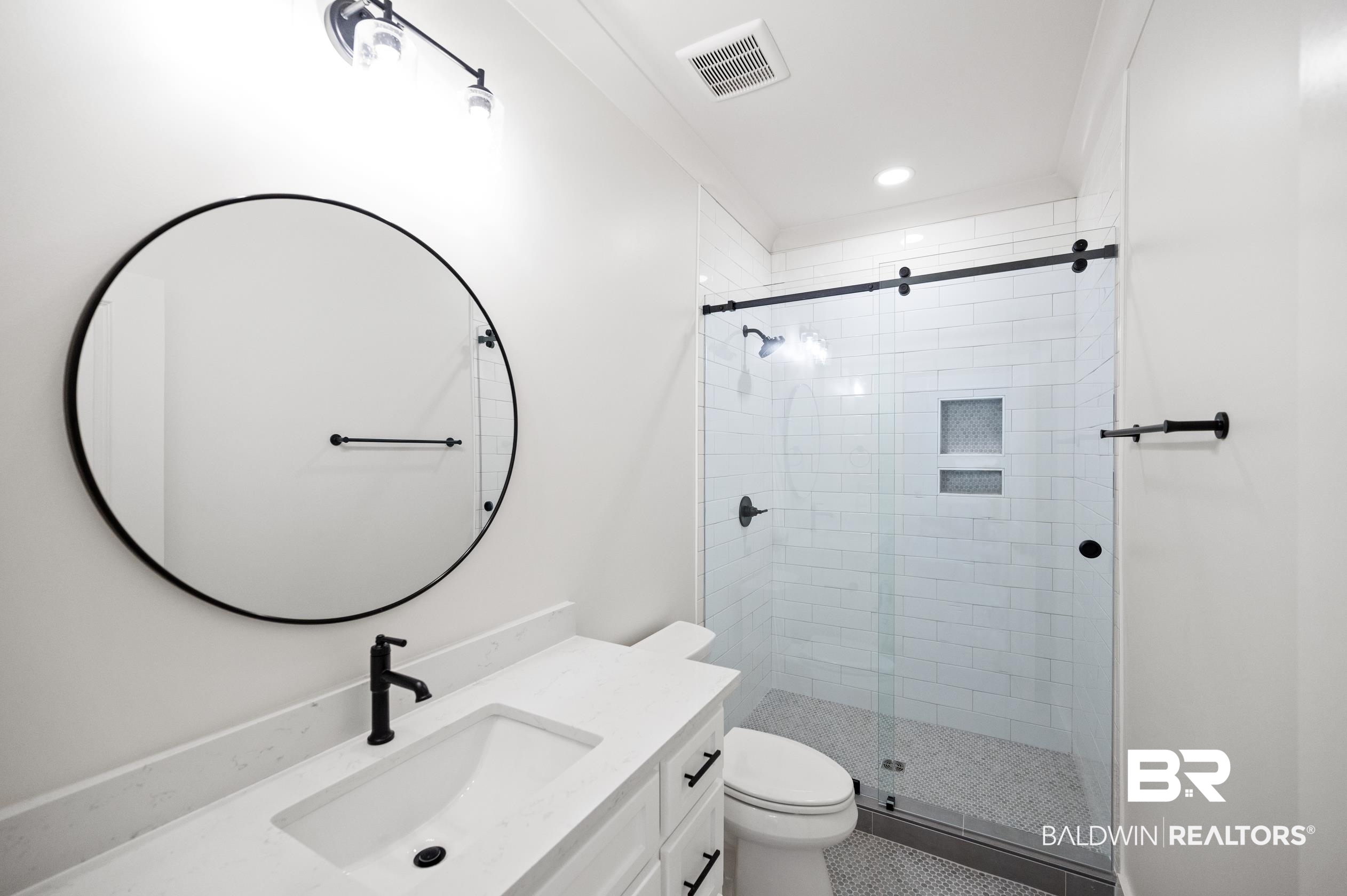 28889 Canal Road Orange Beach, AL 36561 - Photo 33 of 55 Bathroom with tile patterned flooring, vanity, a shower with shower door, and toilet