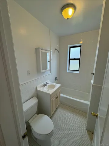 a bathroom with a granite countertop toilet sink and mirror