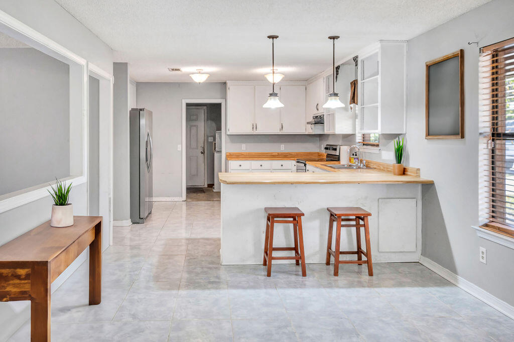 4712 Frontier Road Pace, FL 32571 - Photo 11 of 29 a kitchen with refrigerator and cabinets