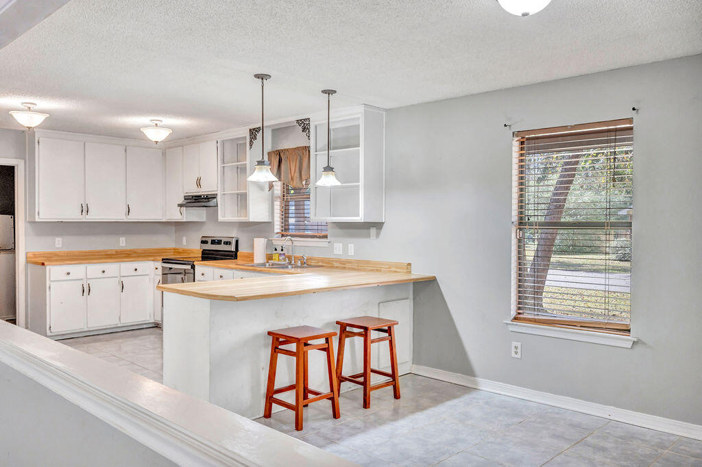 4712 Frontier Road Pace, FL 32571 - Photo 12 of 29 a kitchen with a stove a refrigerator and a sink
