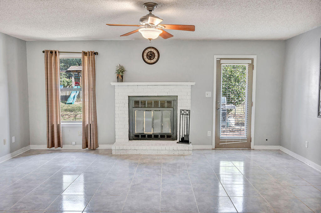 4712 Frontier Road Pace, FL 32571 - Photo 13 of 29 an empty room with windows and fan