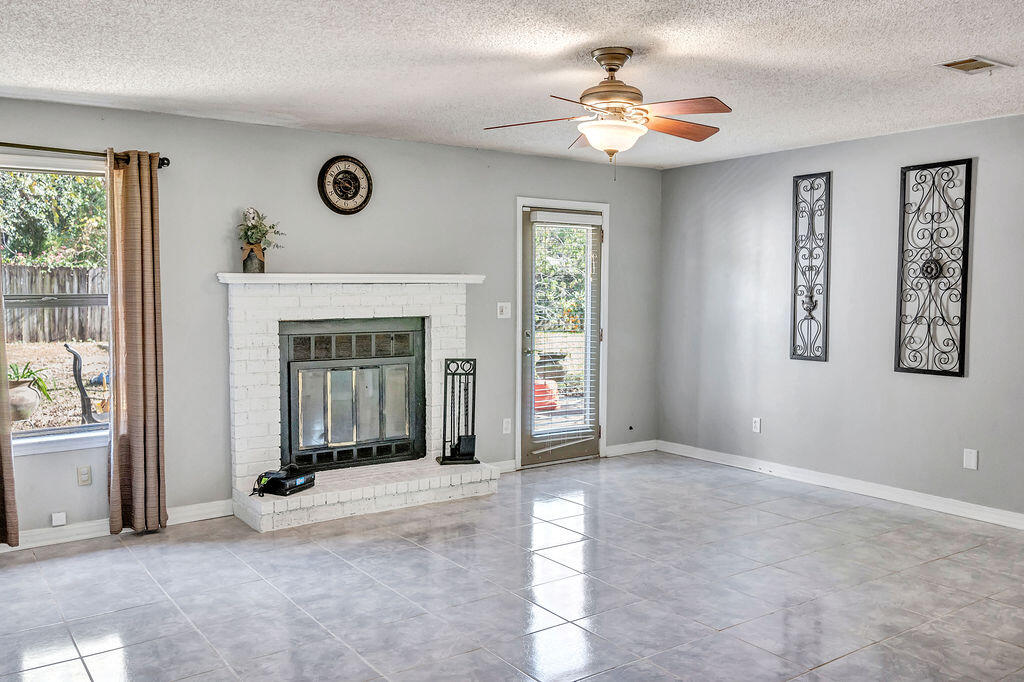 4712 Frontier Road Pace, FL 32571 - Photo 15 of 29 an empty room with windows and fireplace