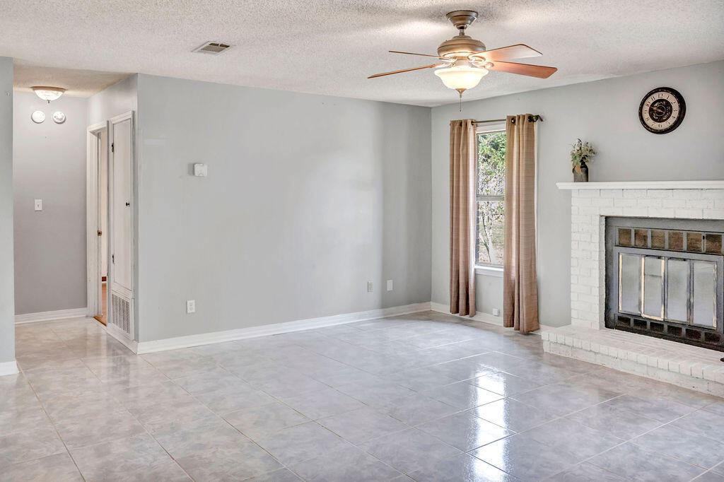 4712 Frontier Road Pace, FL 32571 - Photo 16 of 29 an empty room with windows and fan