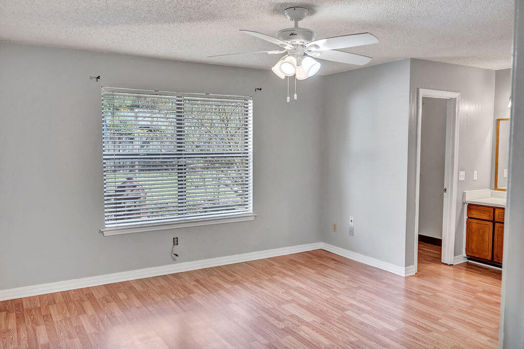 4712 Frontier Road Pace, FL 32571 - Photo 20 of 29 a view of an empty room with a window and wooden floor