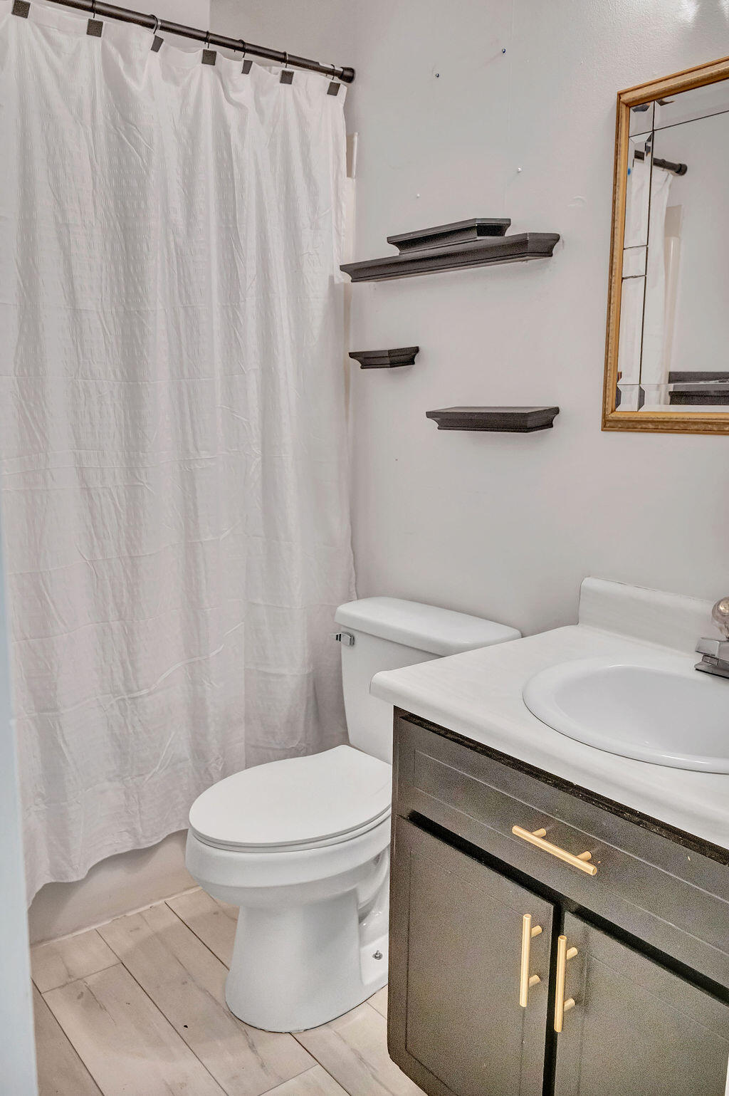 4712 Frontier Road Pace, FL 32571 - Photo 24 of 29 a bathroom with a granite countertop sink toilet and a mirror
