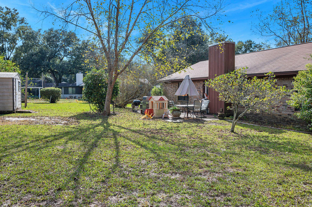 4712 Frontier Road Pace, FL 32571 - Photo 27 of 29 a backyard of a house with a yard and outdoor seating