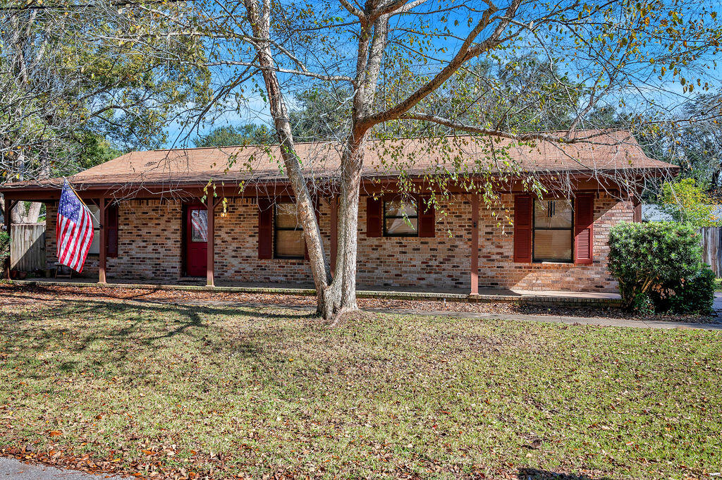 4712 Frontier Road Pace, FL 32571 - Photo 3 of 29 a front view of a house with garden