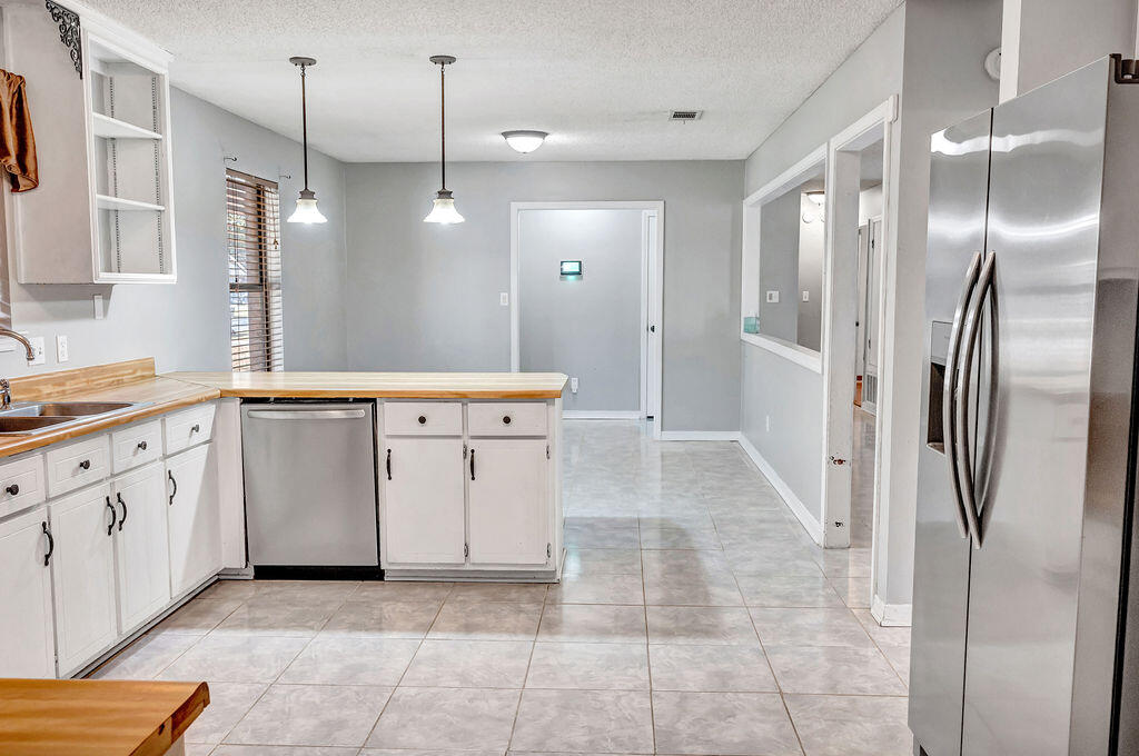 4712 Frontier Road Pace, FL 32571 - Photo 9 of 29 a bathroom with a sink a toilet a large mirror and vanity