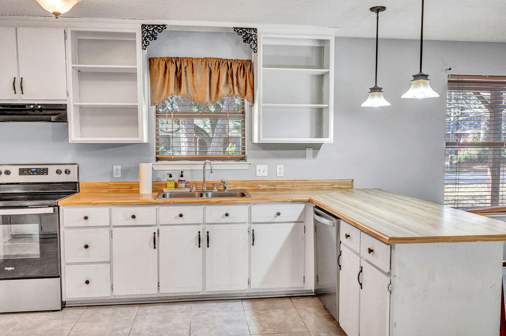 4712 Frontier Road Pace, FL 32571 - Photo 10 of 29 a kitchen with granite countertop white cabinets and white appliances