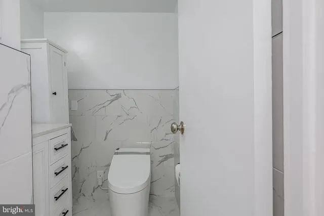 a bathroom with a granite countertop mirror and a toilet