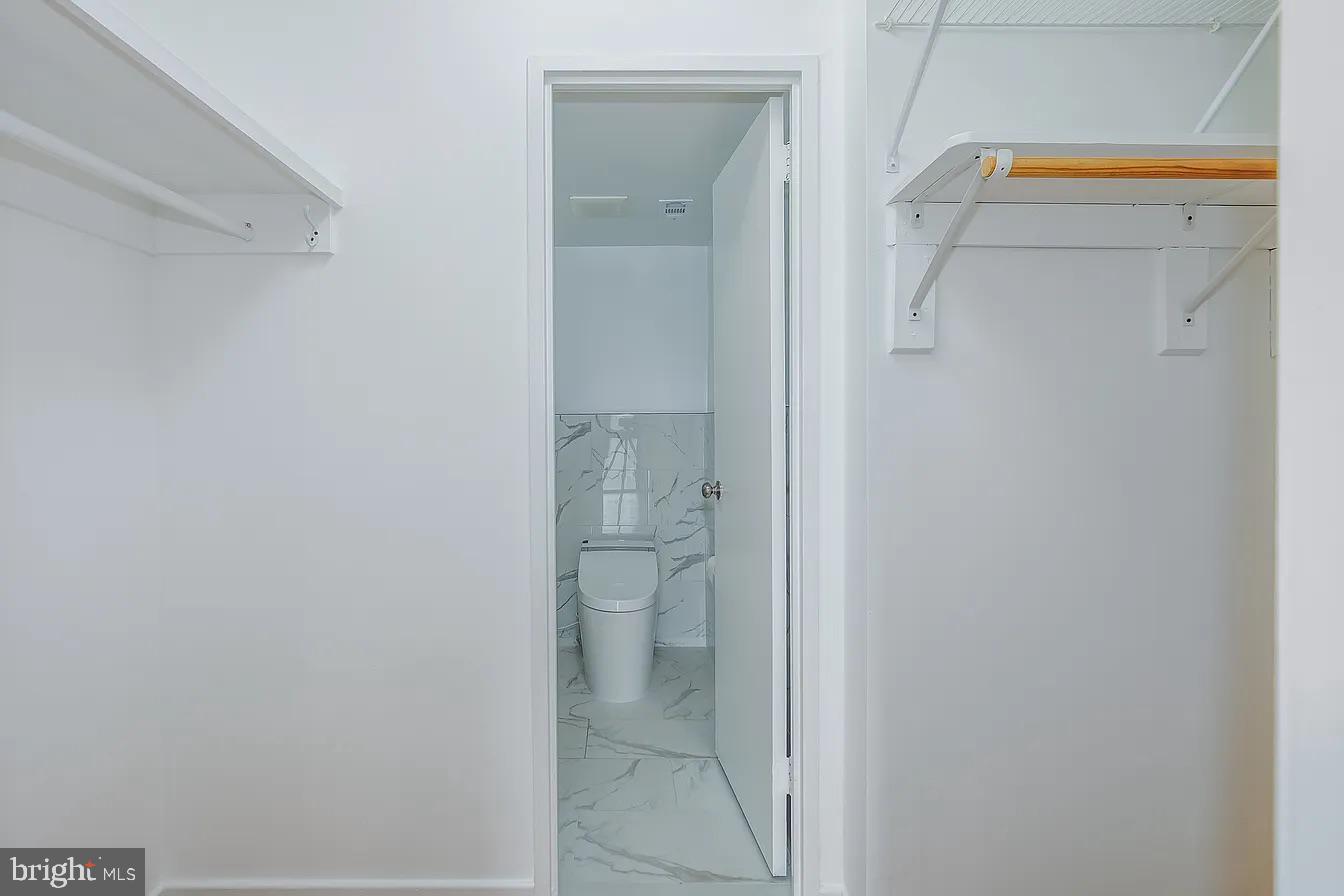 1250 4th Street Southwest, Unit W403 Washington, DC 20024 - Photo 13 of 30 a bathroom with a granite countertop mirror and a toilet
