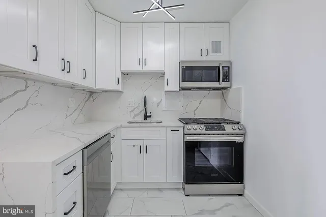 a kitchen with cabinets stainless steel appliances and a sink