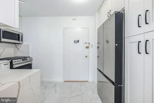 a metallic refrigerator freezer sitting in a kitchen