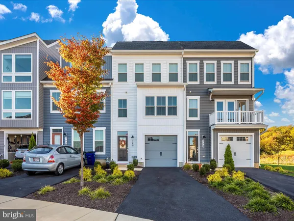 a front view of a building with cars parked
