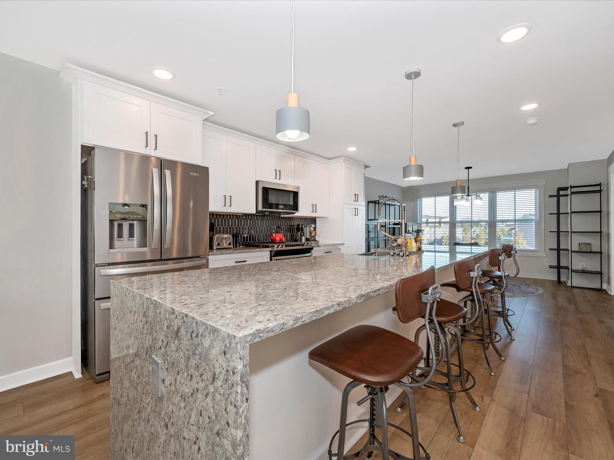 740 Tatum Court Frederick, MD 21702 - Photo 11 of 53 a kitchen with granite countertop a table chairs refrigerator and microwave