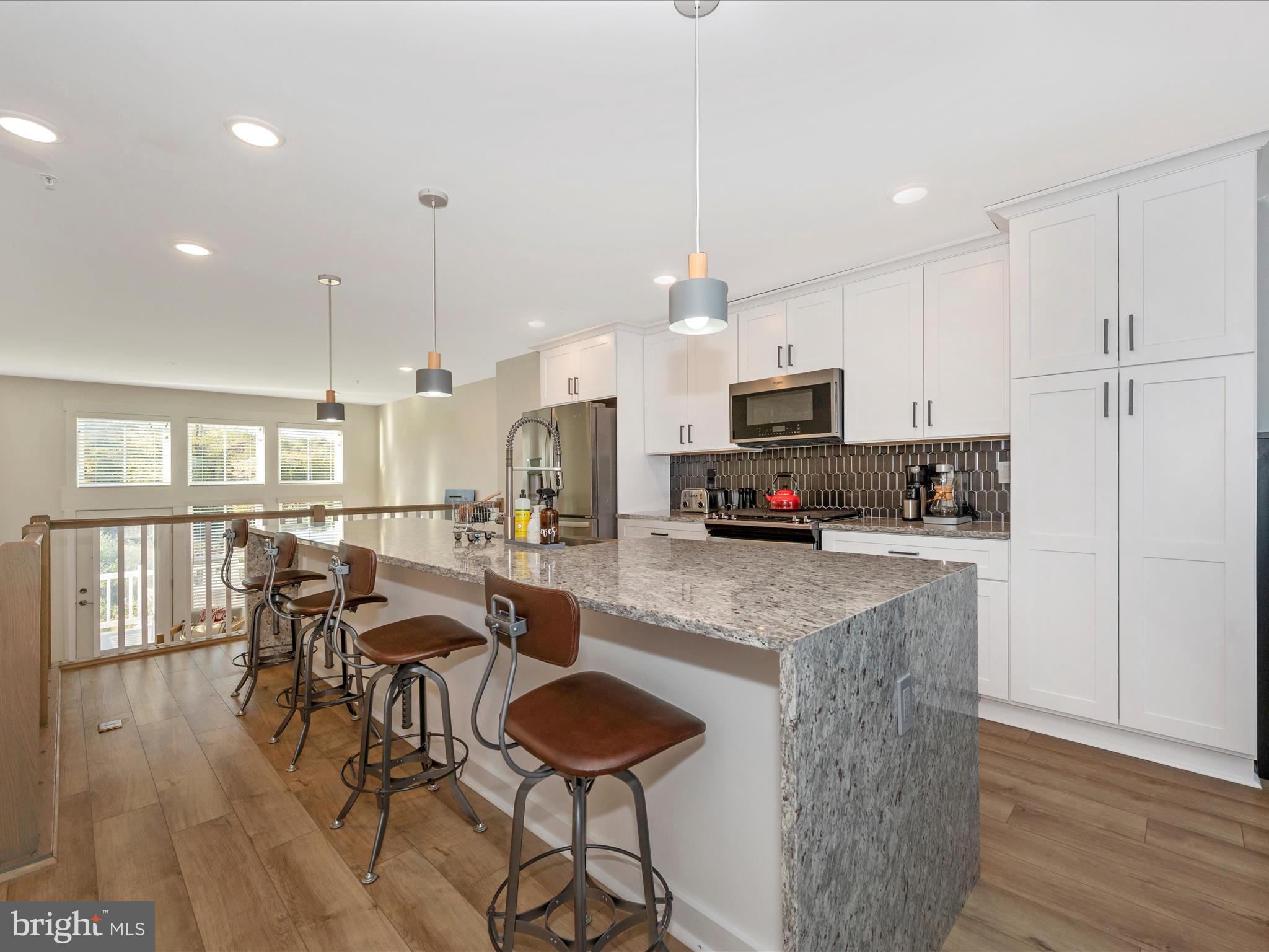 740 Tatum Court Frederick, MD 21702 - Photo 12 of 53 a kitchen with stainless steel appliances granite countertop a stove top oven a sink dishwasher a dining table and chairs with wooden floor