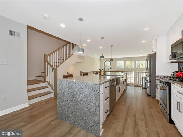 a view of a kitchen with wooden floor and electronic appliances