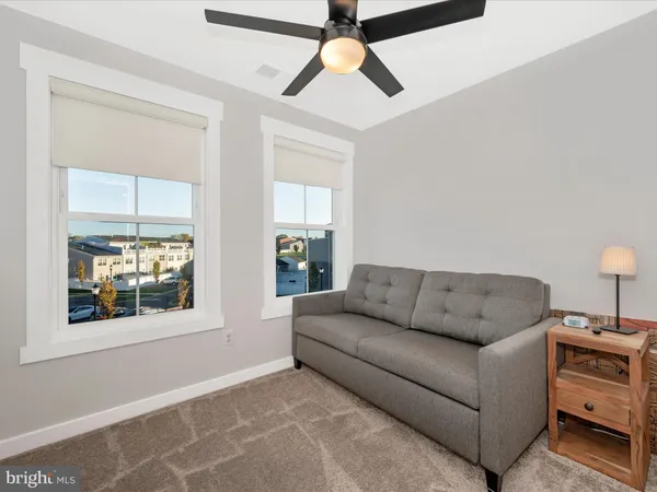 a living room with furniture and a ceiling fan