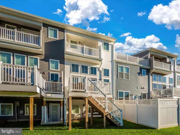 a view of a patio with a table and chairs and floor to ceiling window next to a building