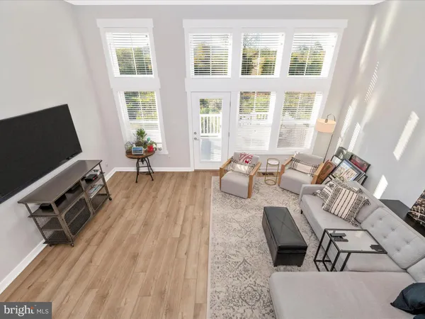 a living room with furniture a flat screen tv and a large window